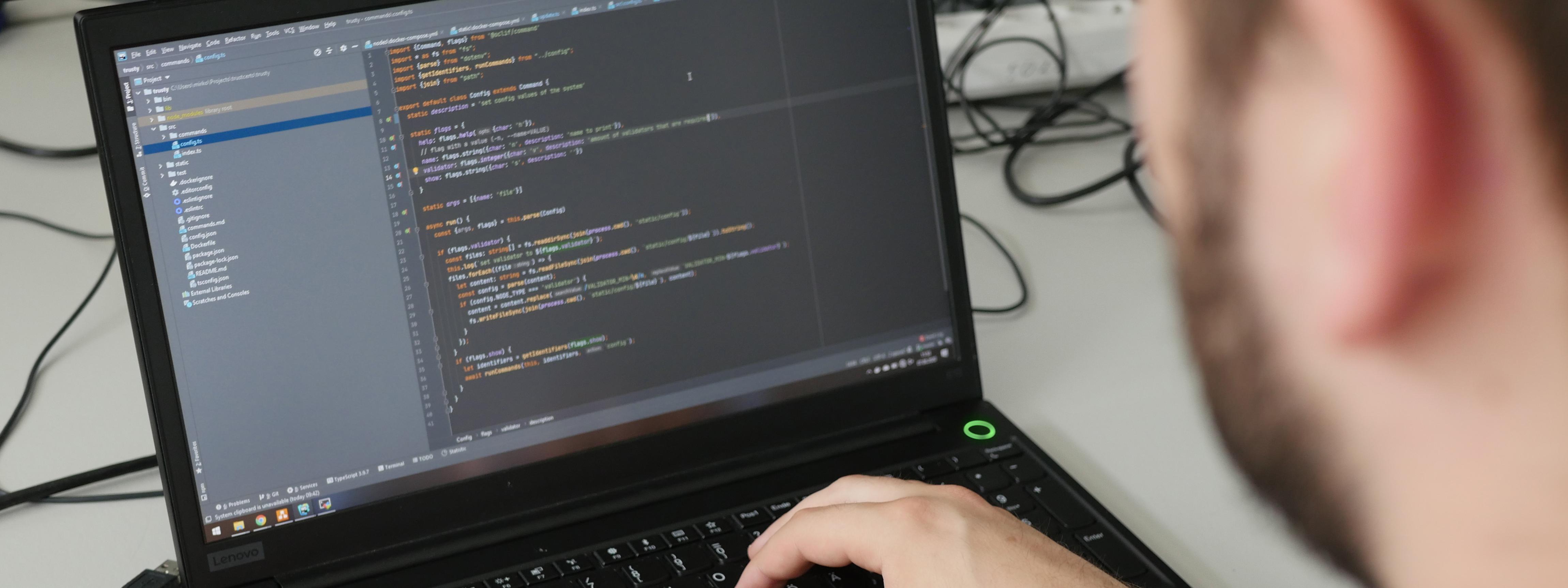 A man doing some coding on a laptop