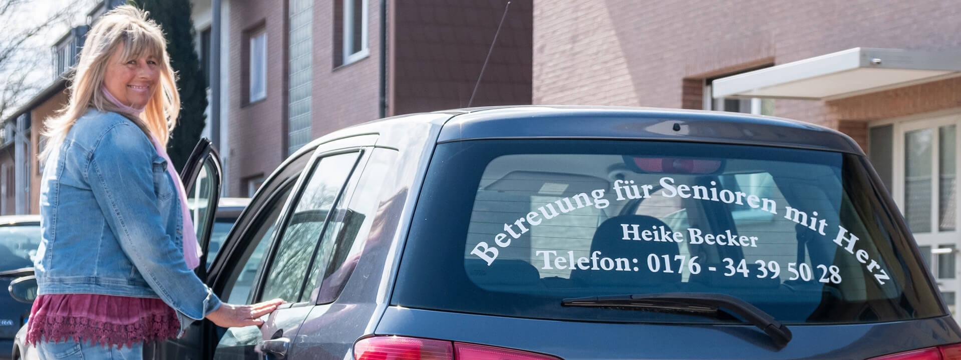 Heike Becker, eine Frau mittleren Alters, an ihrem Auto.