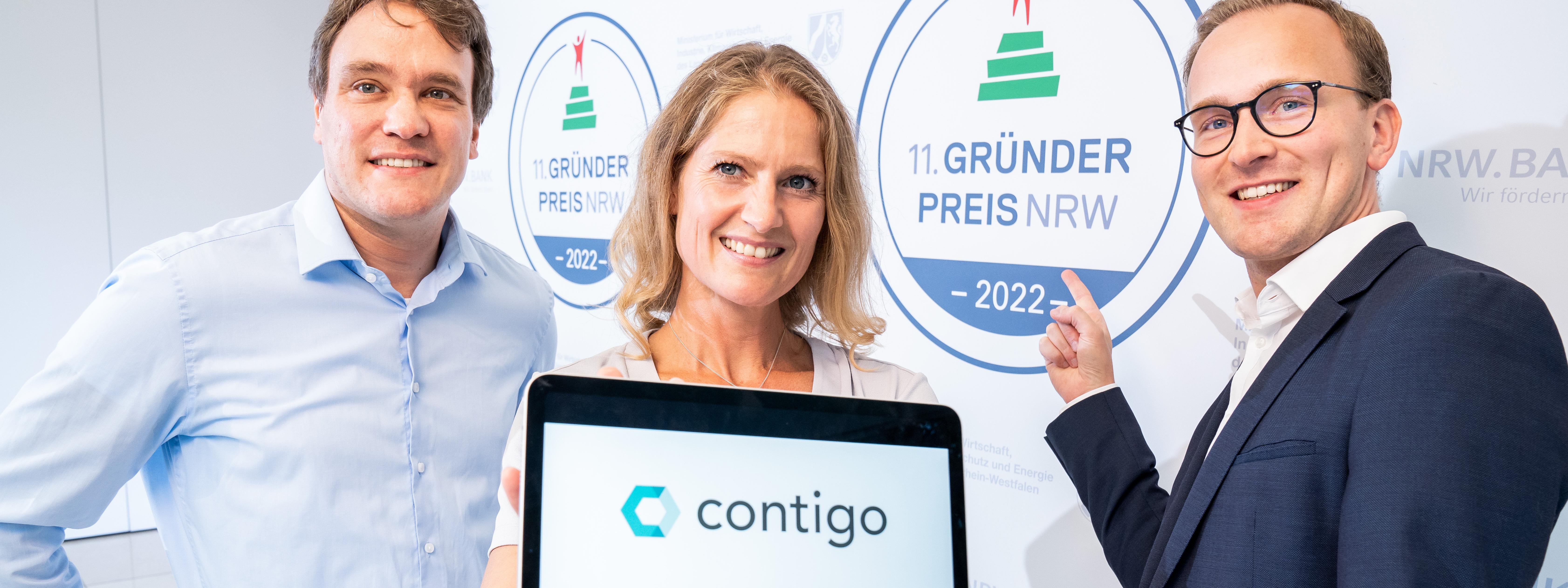 Nicolas Stamer and Sebastian Jansen, between them a woman holding a tablet showing the contigo logo on the display