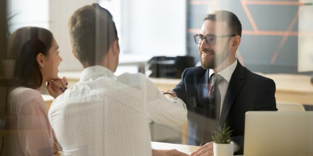 A consultant sitting in conversation with a man and a woman