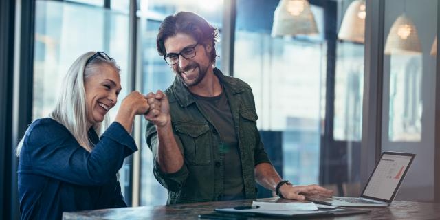 A younger man and an older woman fistbumping