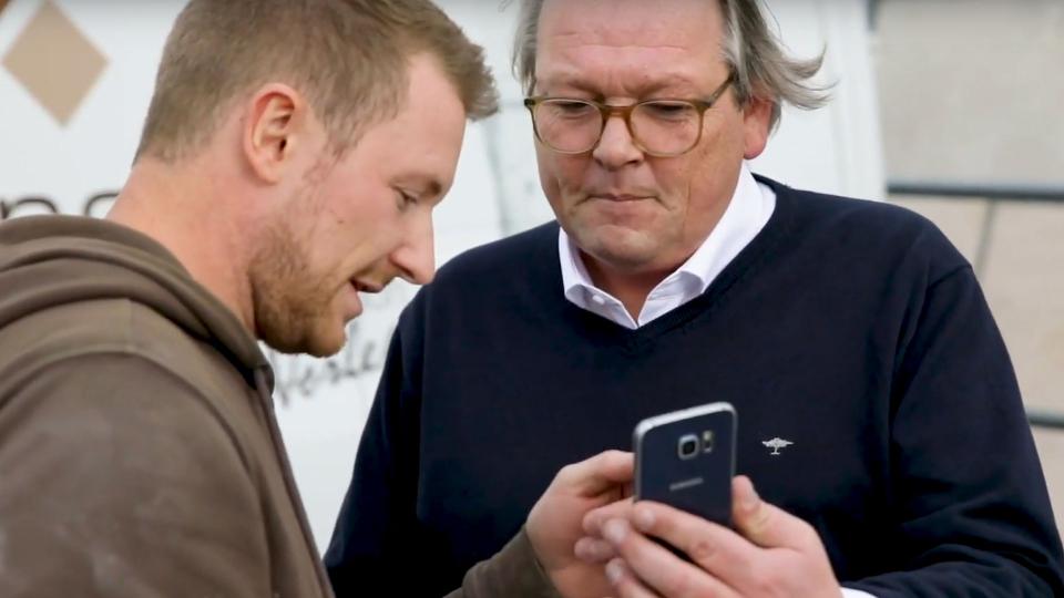 Mario Weidemann and Peter Hagedorn looking at a smartphone.