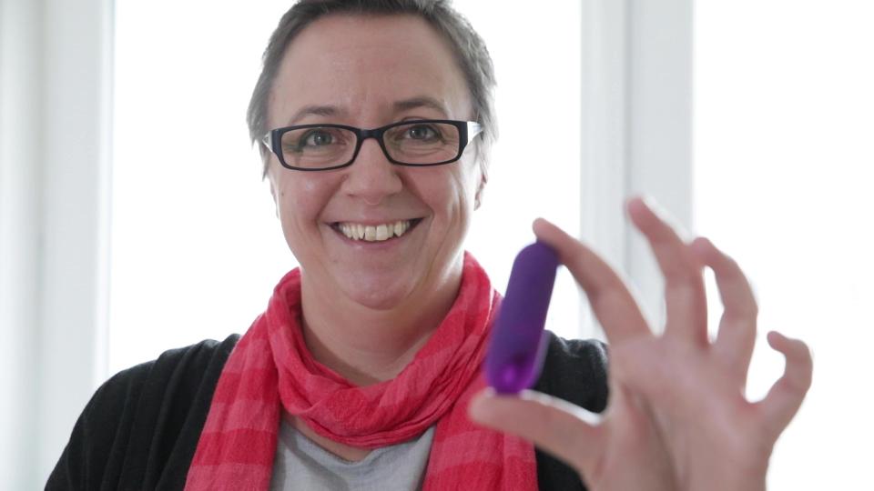 Katrin Reuter, eine Frau mit kurzen Haaren und Brille, hält den trackle-Sensor in die Kamera.