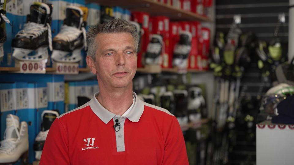 Peter Glinka standing in front of a wall with skates.