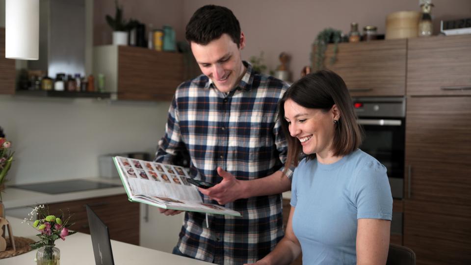 Mann und Frau sehen sich ein Kochbuch an. 