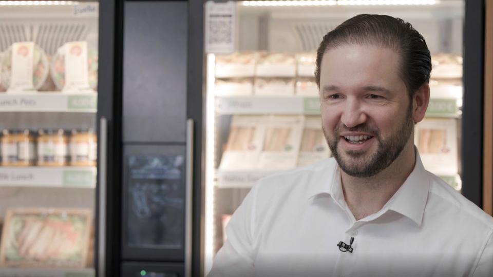 Alexander Eissing vor Kühlschränken mit Essen darin