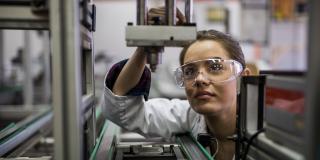 A woman is standing in front of a microscope