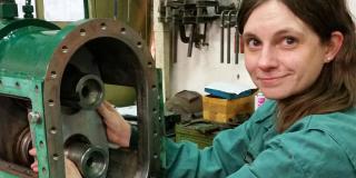 Doris Korthaus, eine junge Frau in Arbeits-Overall, arbeitet an einer Pumpe.