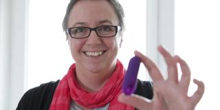 Katrin Reuter, eine Frau mit kurzen Haaren und Brille, hält den trackle-Sensor in die Kamera.
