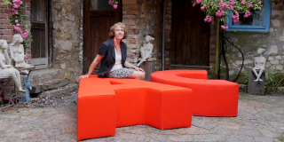 Birgitta Lancé sitting on one of her pieces of outdoor furniture.