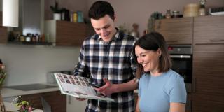 A man and a woman are having a look into a cooking book