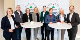 Die Jury-Mitglieder des Gründerpreises stehen an Stehtischen