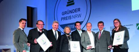 Minister Pinkwart mit den GewinnerInnen des Gründerpreises auf der Bühne