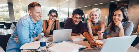 Students sitting around two laptops