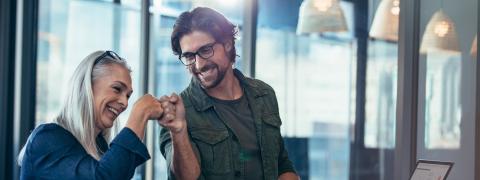 A younger man and an older woman fistbumping