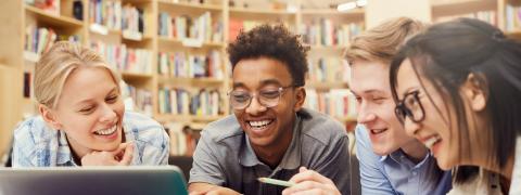 Four students sitting around a laptop