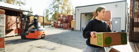 A woman carrying a fruit box