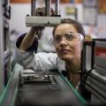 A woman is standing in front of a microscope