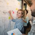 A woman standing in front of a flipchart working on a business plan