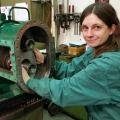 Doris Korthaus, a young woman in work overalls, working at a pump.