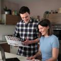 Mann und Frau sehen sich ein Kochbuch an. 