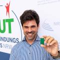 Martin Riebe, Gründer von Incoretex vor dem Logo vom Gründungspreis NRW